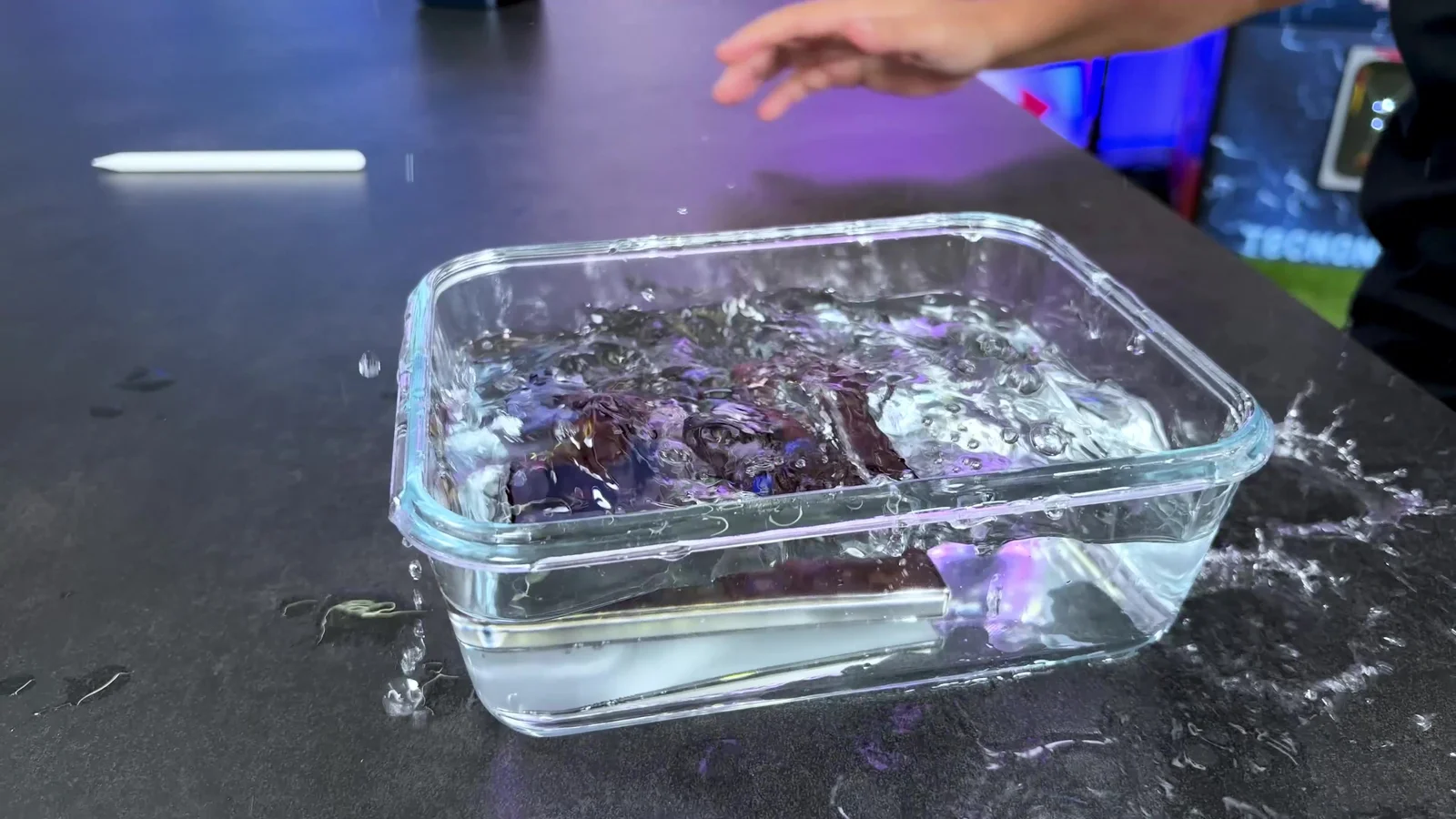 iPhone Duo cayendo dentro de un recipiente con agua en la prueba de resistencia